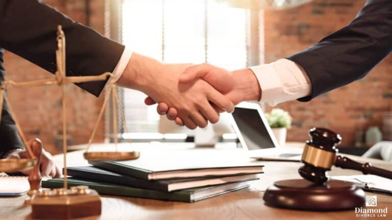 An attorney shaking hands with his client with the scales of justice on his desk