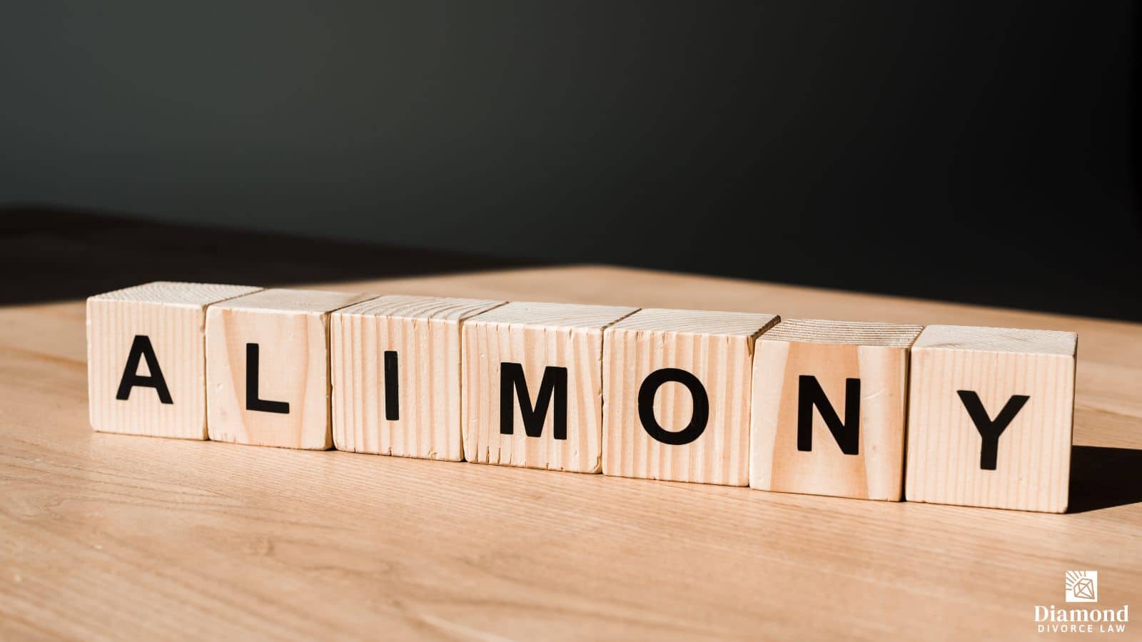 Wooden blocks on a table spelling out the word "alimony".