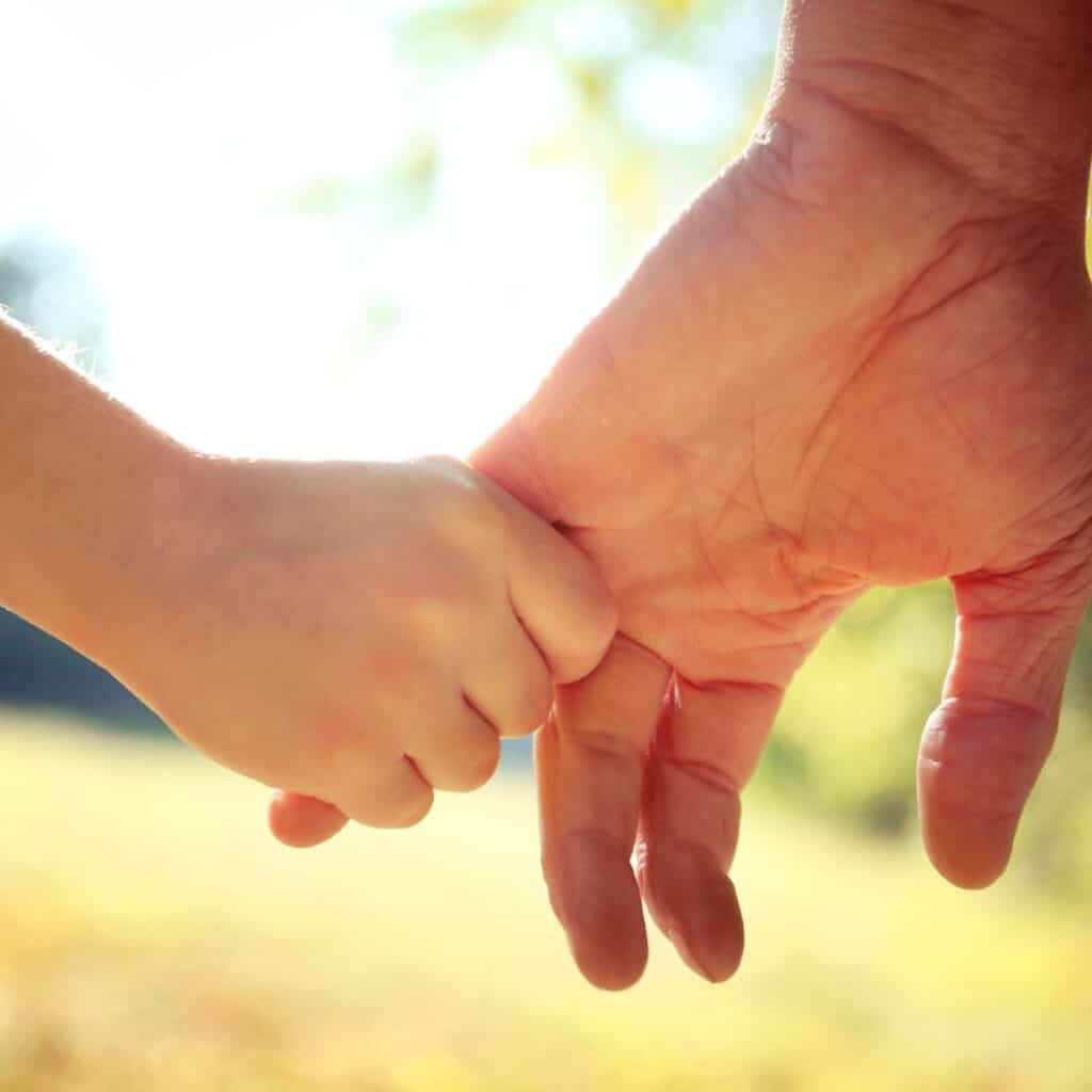 A parent and child holding hands.