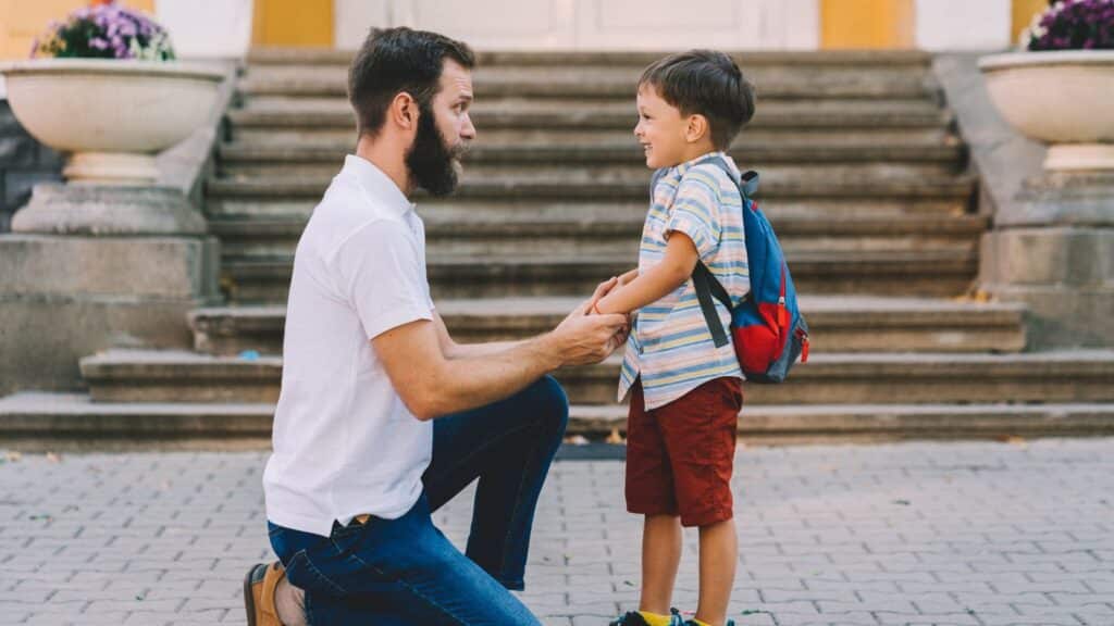 A father talking with his son before school.